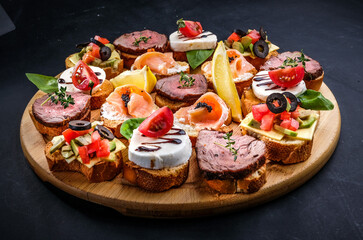 bruschetta with meat, cheese, salmon, lemon, tomato, olive