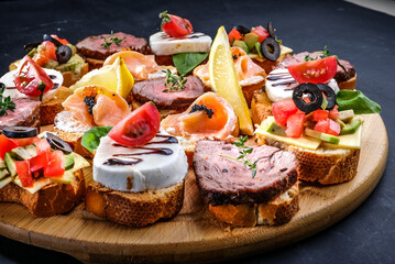 bruschetta with meat, cheese, salmon, lemon, tomato, olive