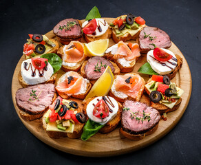 bruschetta with meat, cheese, salmon, lemon, tomato, olive