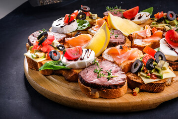 bruschetta with meat, cheese, salmon, lemon, tomato, olive