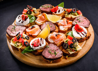 bruschetta with meat, cheese, salmon, lemon, tomato, olive