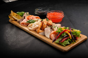 assorted fish and seafood on a wooden tray