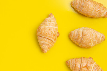 Tasty croissants on yellow background.