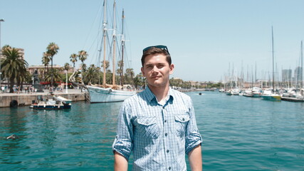 A guy in a blue shirt on the background of the yacht club.