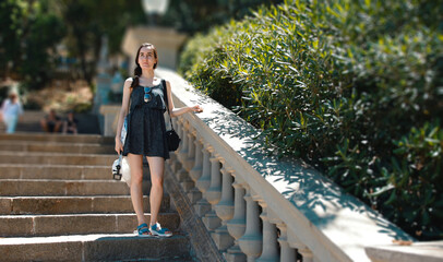A young girl with an action camera is standing on the stairs in a tropical country. Relaxation