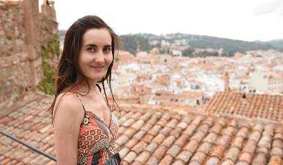 Girl on the background Small and cozy Spanish town. red roofs