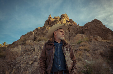 Adult man in cowboy hat against mountain and sky. Almeria, Spain