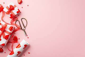 Saint Valentine's Day concept. Top view photo of gift boxes scissors tulle ribbon wrapping paper roll heart shaped chocolate candies and sprinkles on isolated pastel pink background with copyspace