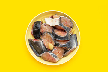 Catfish cut pieces on yellow background.