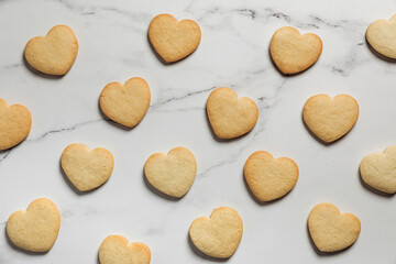 Freshly baked heart shaped shortbread cookies on marble background