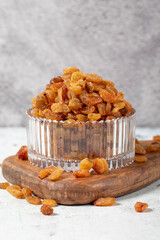 Raisins on stone background. Organic yellow raisins in a glass bowl. Dried healthy nuts. close up