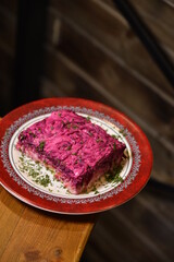 beetroot and potato salad with greens on a red plate