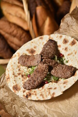 beef kebab shaped with pomegranate seeds and lettuce leaves