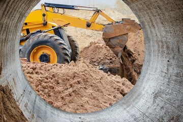 The excavator loader works with a bucket for transporting sand at a construction site. Professional construction equipment for earthworks.