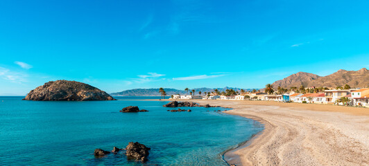 beautiful tropical beach with turquoise sea,  island and typical village ( Mazarron in Andalusia,...