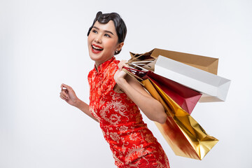 Beautiful Asian woman wearing cheongsam holding shopping bag isolated on white background, Happy Chinese New Year.
