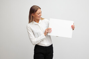Beautiful businesswoman is looking happy and holding a blank paper sheet contract
