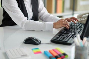 Hands of social worker answering e-mails from people and working with documents on computer