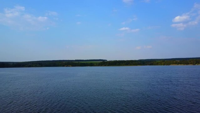 River or lake water on summer windless day. Top view on the beautiful nature with blue horizon.