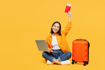 Young IT woman wear summer clothes hold use laptop pc computer show passport ticket isolated on...