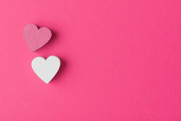 Two Valentine’s hearts on pink background with copy space