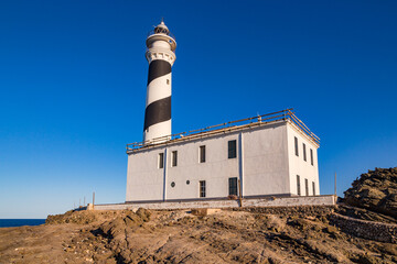 The Far de Favaritx lighthouse painted black and white in a spiral, Menorca, Balearic Islands, Spain