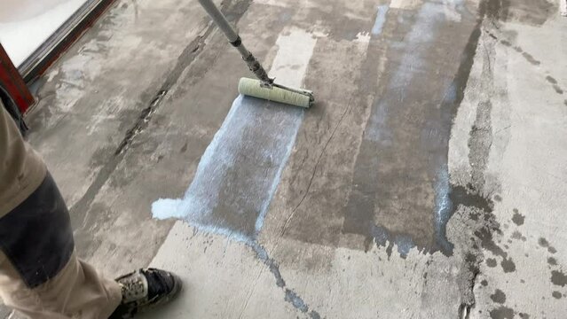 Construction works. 4k video footage with priming the floor surface before further finishing work