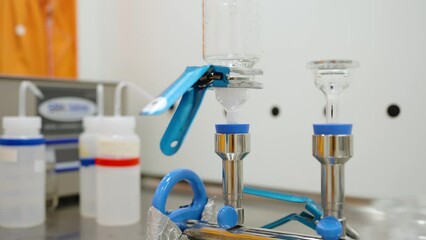 Filtering water through a beaker in a science lab during an experiment. Water running through a beaker during a scientific test.