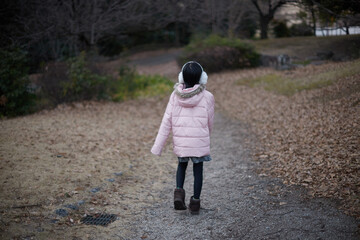 寒い公園で歩く小学生の女の子の姿