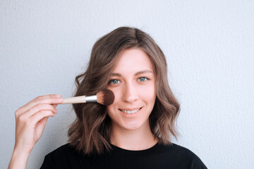 Portrait of a young woman with makeup brushes. Makeup artist.