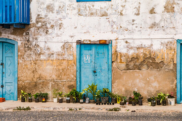 Colonial building with blue doors and old house wall in Sal Rei on Boa Vista island, Cape Verde