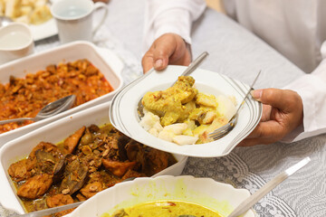 Hand holding a plate of special indonesian food. Traditional menu during Eid mubarak in Indonesia. 