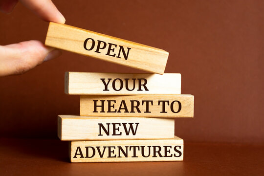 Naklejki Wooden blocks with words 'Open your heart to new adventures'.