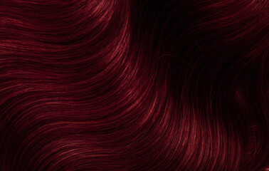 Dark red hair close-up as a background. Women's long brown hair. Beautifully styled wavy shiny...