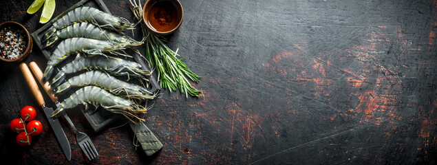 Raw shrimps uncooked with tomatoes and rosemary.