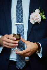 A glass of alcohol in men's hands. Drinks on holidays