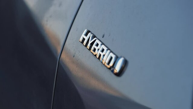 Concept image for hybrid vehicles. Close up view of hybrid logo on a plugin hybrid car. Romania, 2023.