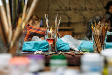 Brushes of different sizes and shapes, on a background of paints