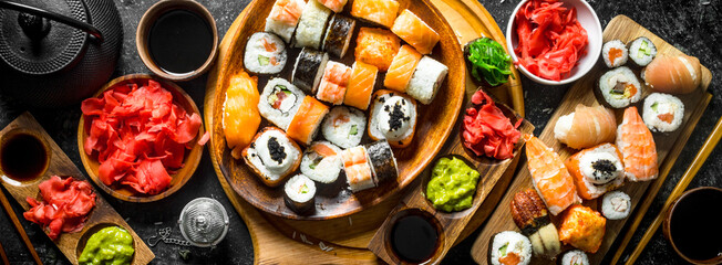 Set traditional Japanese sushi rolls on cutting boards.