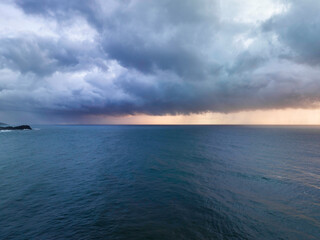 Fototapeta na wymiar Rain clouds and storm light sunrise seascape