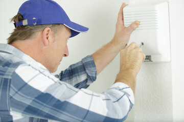 Naklejka na ściany i meble mature electrician installing alarm system