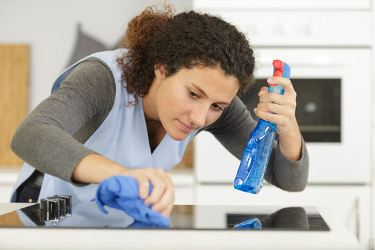 positive woman cleaning with a spray detergent