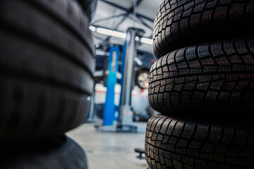 Selective focus on brand new tires in mechanic's shop.
