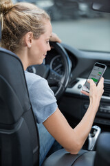 young woman talking on mobile phone in car