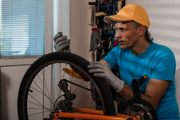 Obraz na płótnie Canvas Cyclist man repairing bicycle wheel with wrench tool