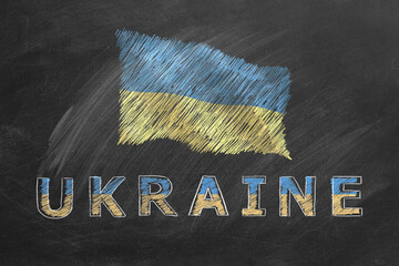Flag of Ukraine with lettering UKRAINE drawing with chalk on a blackboard.