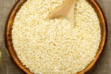 Healthy food and drink concept. Sesame seeds close up in a bowl on a rustic table. Selective focus