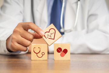 A doctor hand holding wooden cubes with icons of health
