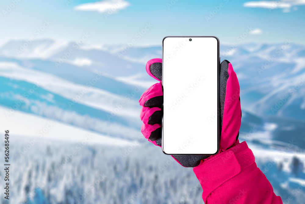 Poster Using a mobile phone at the ski resort. Isolated display for promoting ski or mountaineering app. Phone in hand with pink glove. Ski resort in background