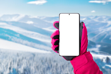 Using a mobile phone at the ski resort. Isolated display for promoting ski or mountaineering app....